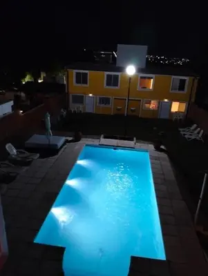 a swimming pool at night with a building in the background at A carlos paz voy in Villa Carlos Paz