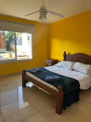 a bedroom with a bed with yellow walls and a window at A carlos paz voy in Villa Carlos Paz