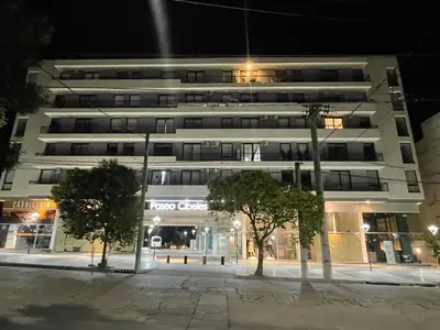a large white building with trees in front of it at Centro Carlos Paz Cibeles in Villa Carlos Paz