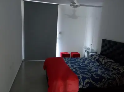 a bedroom with a bed and two red chairs at Centro Carlos Paz Cibeles in Villa Carlos Paz
