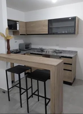 a kitchen with a wooden counter with stools in it at Centro Carlos Paz Cibeles in Villa Carlos Paz