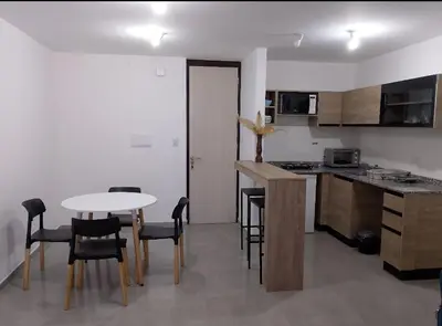 a kitchen with a table and chairs in a room at Centro Carlos Paz Cibeles in Villa Carlos Paz