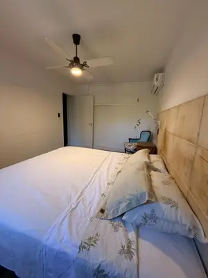 a bedroom with a white bed with a ceiling fan at Departamento Córdoba IV, estadio Kempes, Siglo 21,Cerro de las Rosas, Chateau in Cordoba