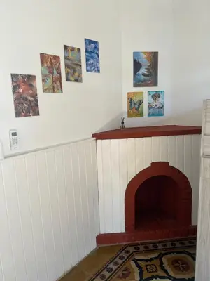 a room with a fireplace with pictures on the wall at La Petrona in Alta Gracia
