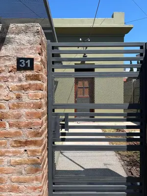 a gate to a house with the number on it at La Petrona in Alta Gracia