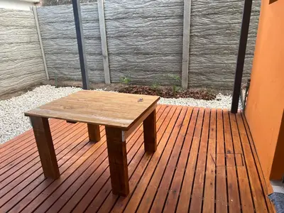a wooden table sitting on a deck on a porch at La Petrona in Alta Gracia