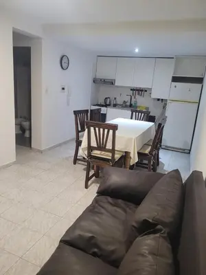 a living room with a couch and a table and a kitchen at Departamento en Cordoba in Cordoba