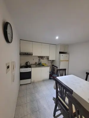 a kitchen with white cabinets and a table in it at Departamento en Cordoba in Cordoba