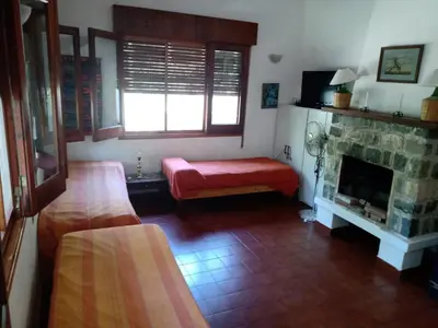 a living room with a fireplace and a red bench at Casa Ortiz in Villa Canada del Sauce