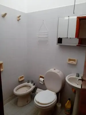 a white bathroom with a toilet and a sink at Casa Ortiz in Villa Canada del Sauce