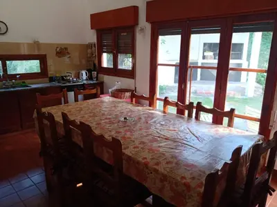 a kitchen with a table with chairs and a tableasteryasteryasteryasteryasteryastery at Casa Ortiz in Villa Canada del Sauce