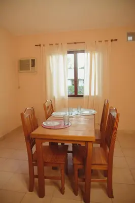 a wooden dining room table with chairs and a window at Departamento en Embalse in Embalse
