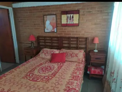 a bedroom with a bed and a brick wall at Monoambiente con piscina compartida in Mina Clavero