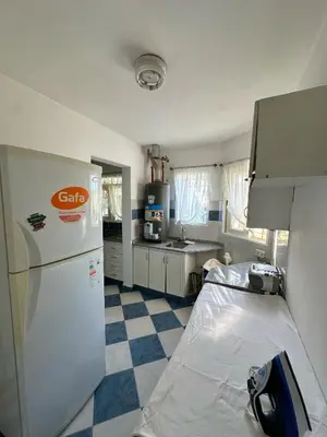 a kitchen with a white refrigerator and a checkered floor at El GOLF in Alta Gracia