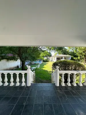 a view from the porch of a house with a white railing at El GOLF in Alta Gracia