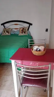 a room with a bed and a table with a red table sidx sidx sidx at Rincón de las Calandrias Embalse in Embalse