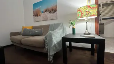a living room with a couch and a table with a lamp at CENTRO CORDOBA departamento 2 dormitorios in Cordoba