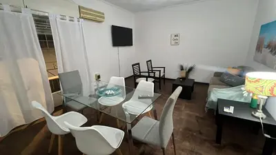 a living room with a glass table and white chairs at CENTRO CORDOBA departamento 2 dormitorios in Cordoba