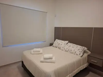 a bedroom with a bed with two towels on it at Complejo San roque in San Roque