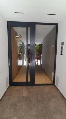 a hallway with glass doors in a building at El Nuevo Obispo, ubicación 5 estrellas, balcón y pileta in Cordoba