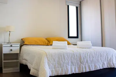 a bedroom with a bed with two pillows and a window at El Nuevo Obispo, ubicación 5 estrellas, balcón y pileta in Cordoba