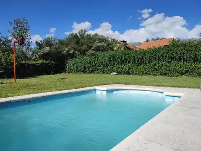 a swimming pool with blue water in a yard at La Aurora in Merlo