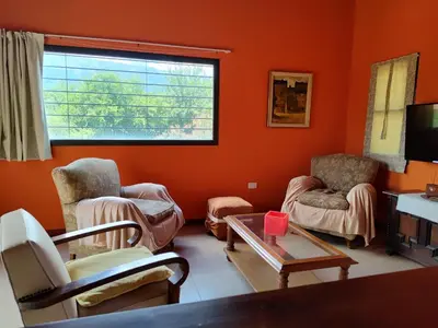 a living room with orange walls and chairs and a table at La Aurora in Merlo
