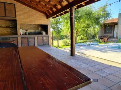 a patio with a wooden table and an outdoor kitchen at La Aurora in Merlo