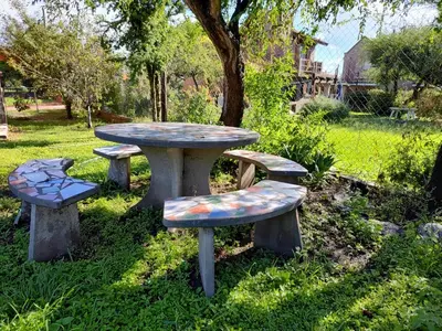 a picnic table and benches in a park at La Aurora in Merlo
