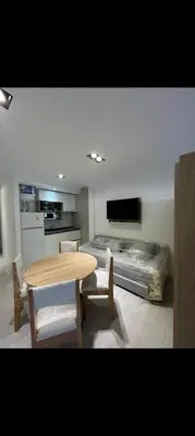 a room with a table and a kitchen with a bed at Departamento Miralejos 16 in Villa Carlos Paz