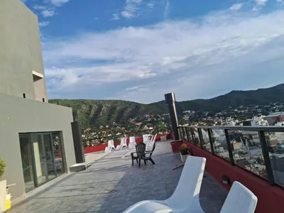 a balcony with chairs and a view of a city at Departamento Miralejos 16 in Villa Carlos Paz