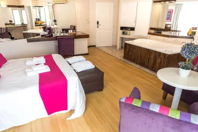a bedroom with a large bed and a bathroom at Santa Cecilia Resort & Spa I in Villa Carlos Paz
