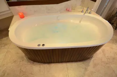 a large bath tub in a bathroom with a candle at Santa Cecilia Resort & Spa I in Villa Carlos Paz
