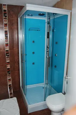a glass shower in a bathroom with a toilet at Santa Cecilia Resort & Spa I in Villa Carlos Paz