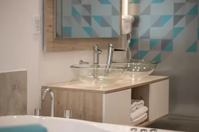a bathroom with two glass bowl sinks on a counter at Santa Cecilia Resort & Spa I in Villa Carlos Paz