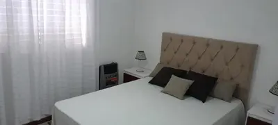 a bedroom with a large white bed with a large headboard at Mis 4 estaciones in Villa Carlos Paz