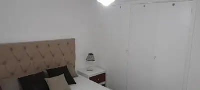 a bedroom with a bed and a lamp on a nightstand at Mis 4 estaciones in Villa Carlos Paz