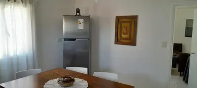 a kitchen with a table and a refrigerator at Mis 4 estaciones in Villa Carlos Paz