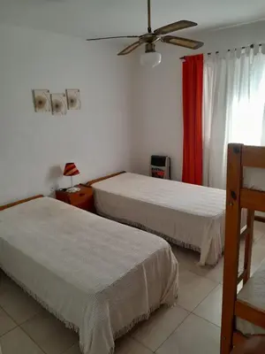 a bedroom with two beds and a ceiling fan at Mis 4 estaciones in Villa Carlos Paz