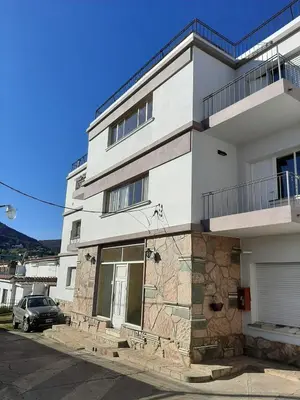 a white building with a car parked in front of it at Mis 4 estaciones in Villa Carlos Paz