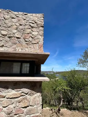 a stone house with a window on the side of it at Refugio de las Nubes in Las Rabonas