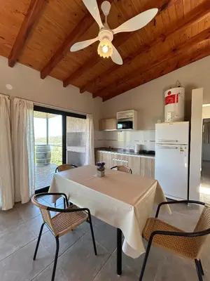 a kitchen with a table and a ceiling fan at Refugio de las Nubes in Las Rabonas