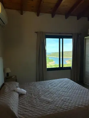 a bedroom with a bed and a large window at Refugio de las Nubes in Las Rabonas