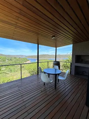 a table and chairs on a deck with a view at Refugio de las Nubes in Las Rabonas