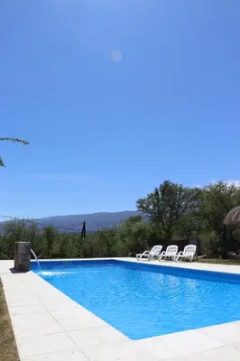 a swimming pool with two chairs and a swimming pool at Refugio de las Nubes in Las Rabonas
