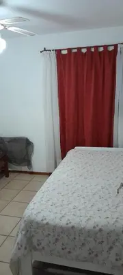 a bedroom with a bed and a red curtain at Complejo Pichona - Villa Carlos Paz - San Antonio in San Antonio de Arredondo