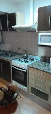 a kitchen with a stove with a pot on it at Complejo Pichona - Villa Carlos Paz - San Antonio in San Antonio de Arredondo