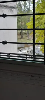 a window with a view of a park seen through it at Complejo Pichona - Villa Carlos Paz - San Antonio in San Antonio de Arredondo
