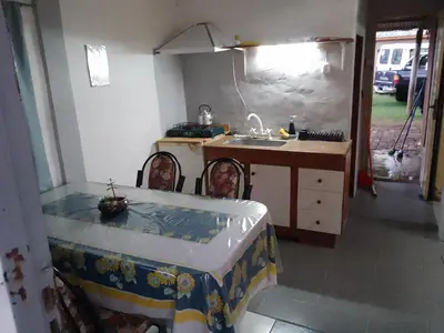 a kitchen with a table and a sink and a counter at Dpto Bordo in Villa Cura Brochero