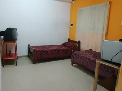 a room with two beds and a flat screen tv at Dpto Bordo in Villa Cura Brochero